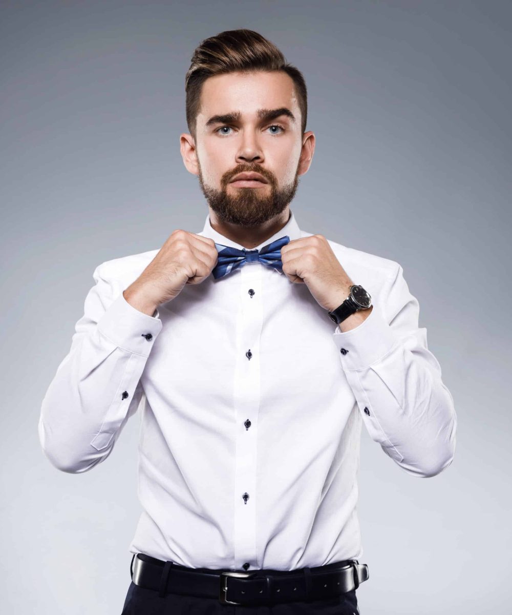 Stylish handsome male model wearing a classic suit with bow-tie